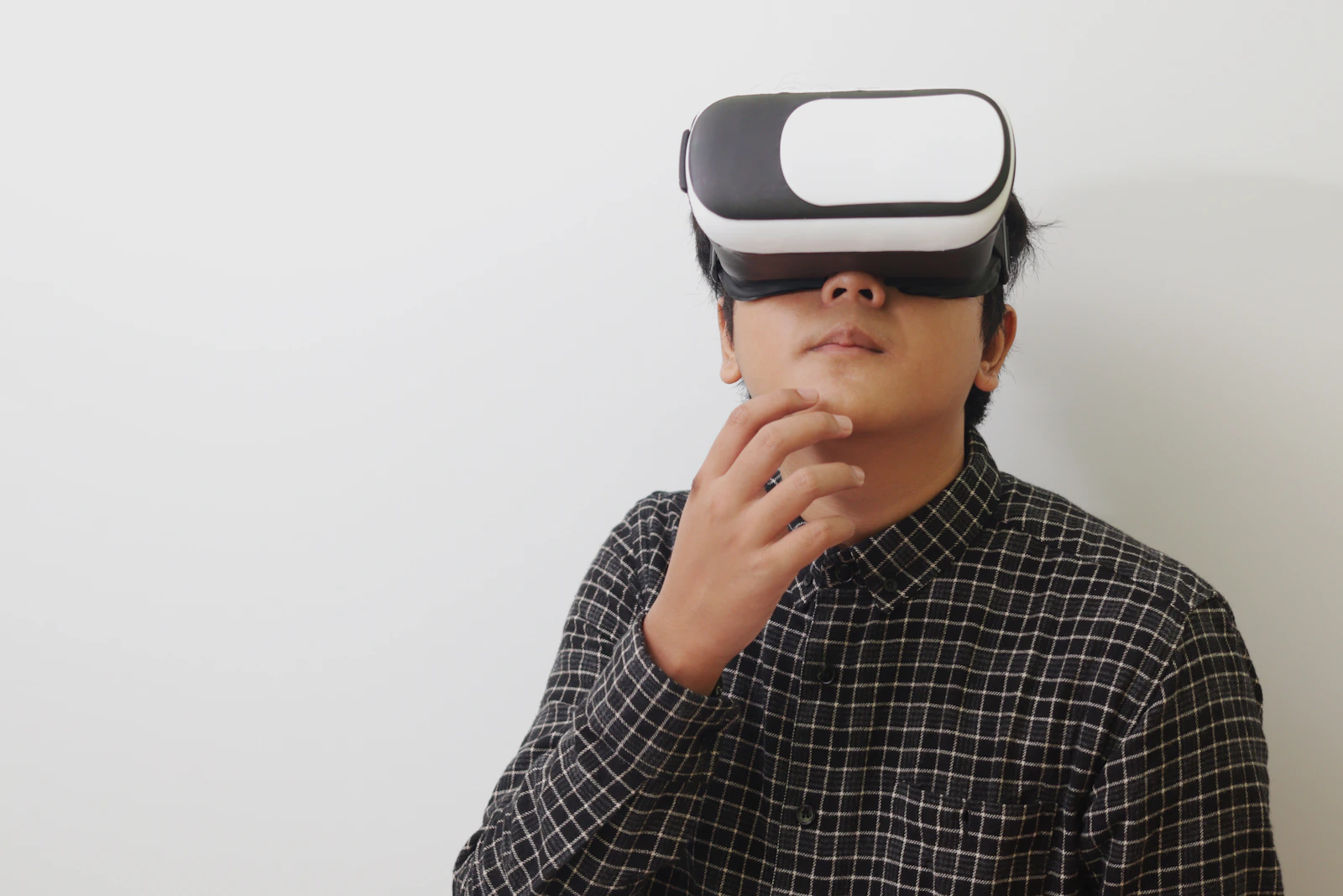 A person wearing a virtual reality headset, exploring with one hand raised